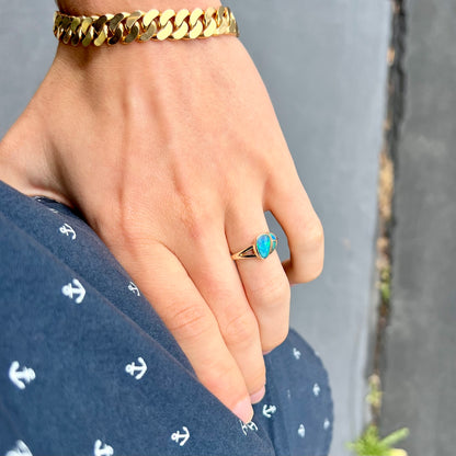 A ladies' black opal inlay ring cast in yellow gold.