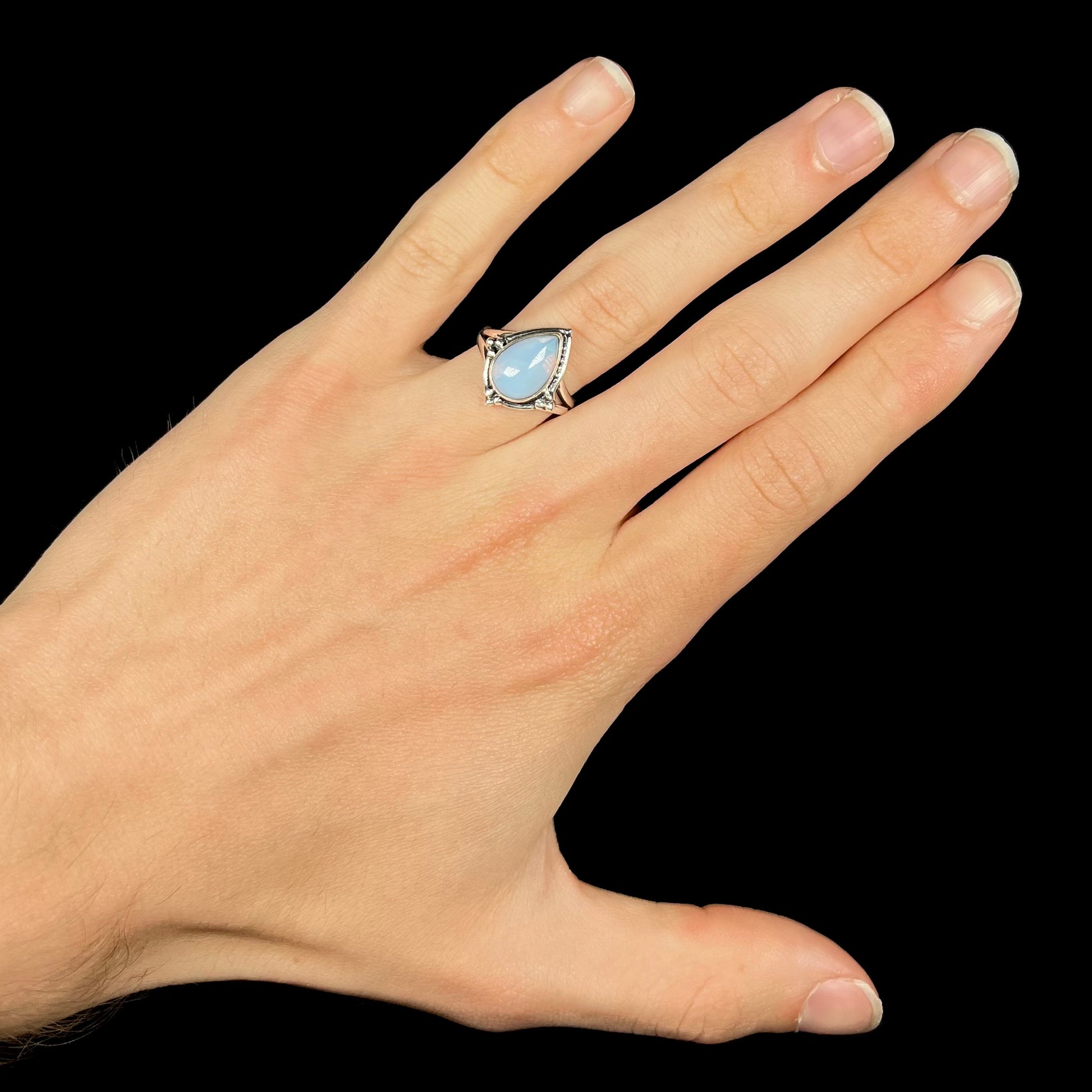 A handmade white metal ring set with a pear shaped opalite cabochon.