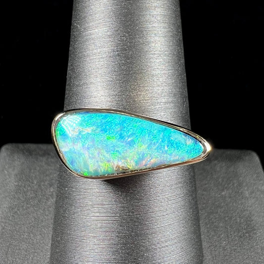 A ladies yellow gold solitaire ring bezel set with a natural opalized seashell from Coober Pedy, Australia.