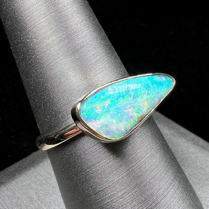 A ladies yellow gold solitaire ring bezel set with a natural opalized seashell from Coober Pedy, Australia.