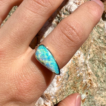 A ladies yellow gold solitaire ring bezel set with a natural opalized seashell from Coober Pedy, Australia.