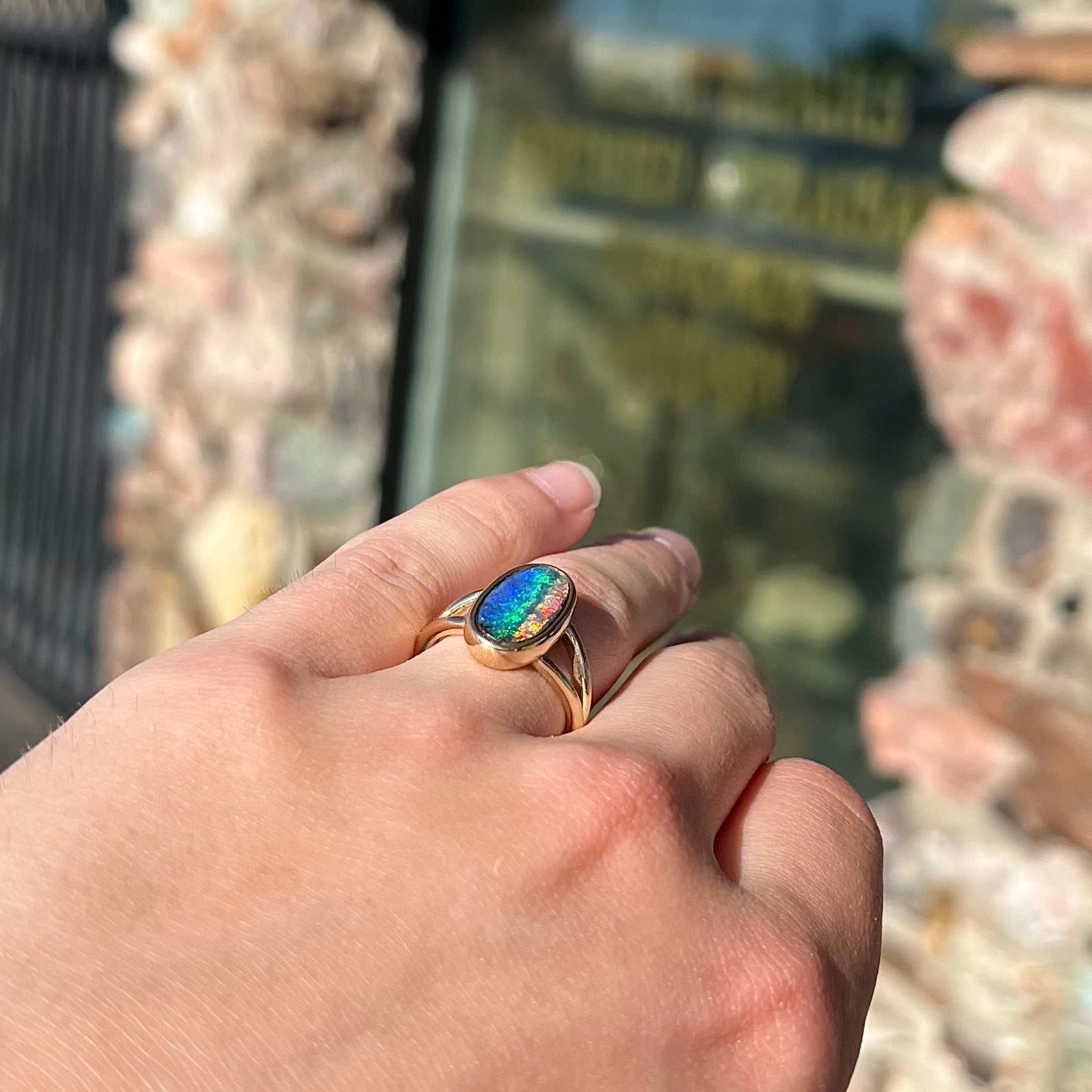 A ladies' yellow gold split shank solitaire ring set with a natural Australian black boulder opal.
