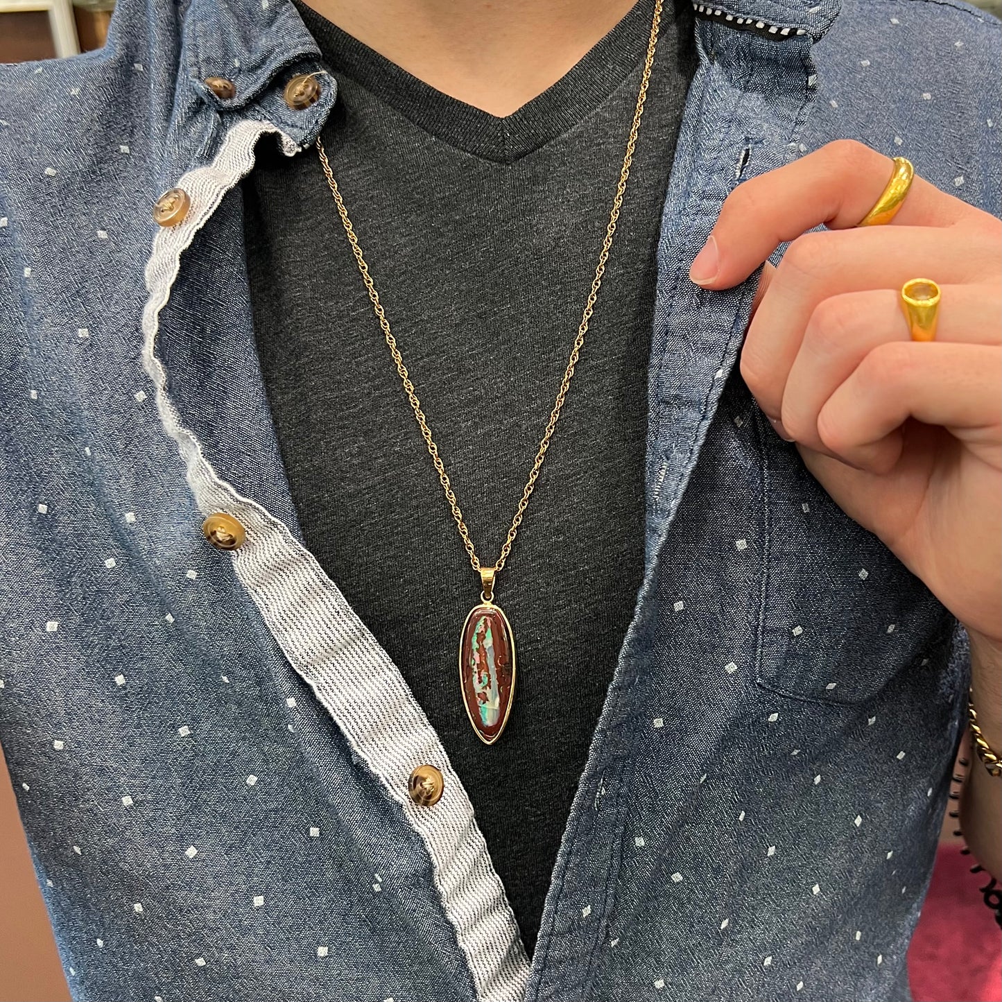 A yellow gold pendant set with a natural Yowah nut boulder opal stone.