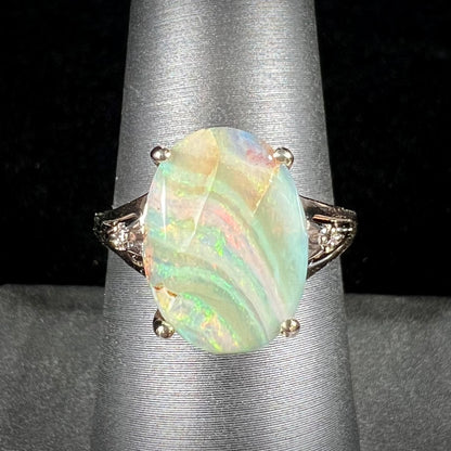 A ladies' Australian boulder opal ring set in yellow gold with diamond accents.  The opal shimmers green and pink and has fissure inclusions.