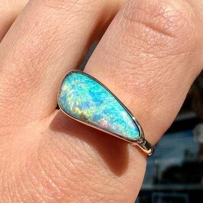 A ladies yellow gold solitaire ring bezel set with a natural opalized seashell from Coober Pedy, Australia.