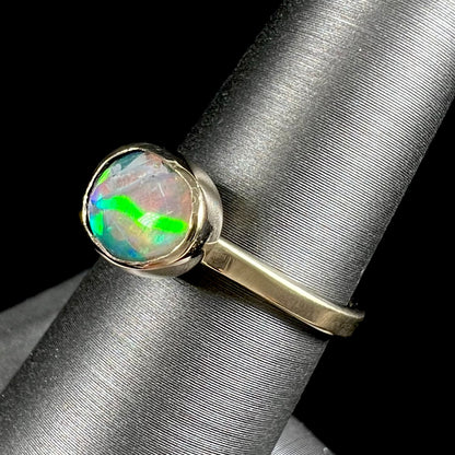 A yellow gold solitaire ring set with a natural Australian cat's eye opal stone.