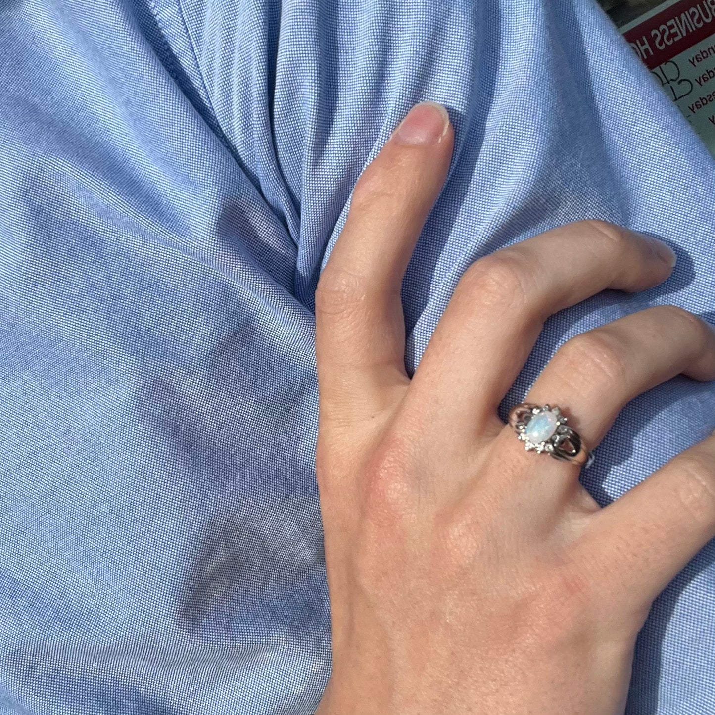 A ladies' white gold ring set with a halo of diamonds and an oval cabochon cut Australian opal.