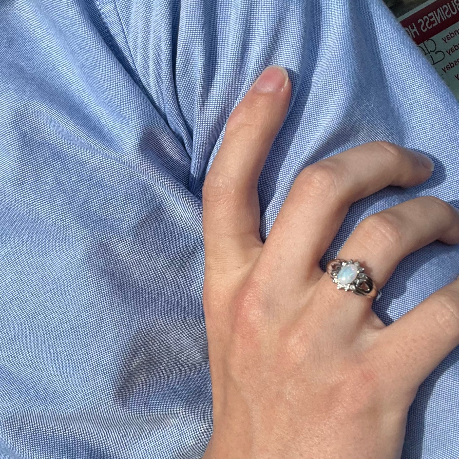 A ladies' white gold ring set with a halo of diamonds and an oval cabochon cut Australian opal.