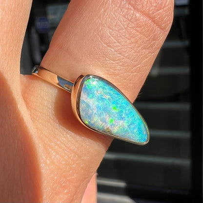 A ladies yellow gold solitaire ring bezel set with a natural opalized seashell from Coober Pedy, Australia.