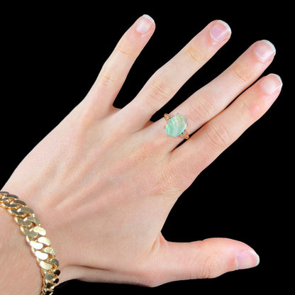 A ladies' Australian boulder opal ring set in yellow gold with diamond accents.  The opal shimmers green and pink and has fissure inclusions.