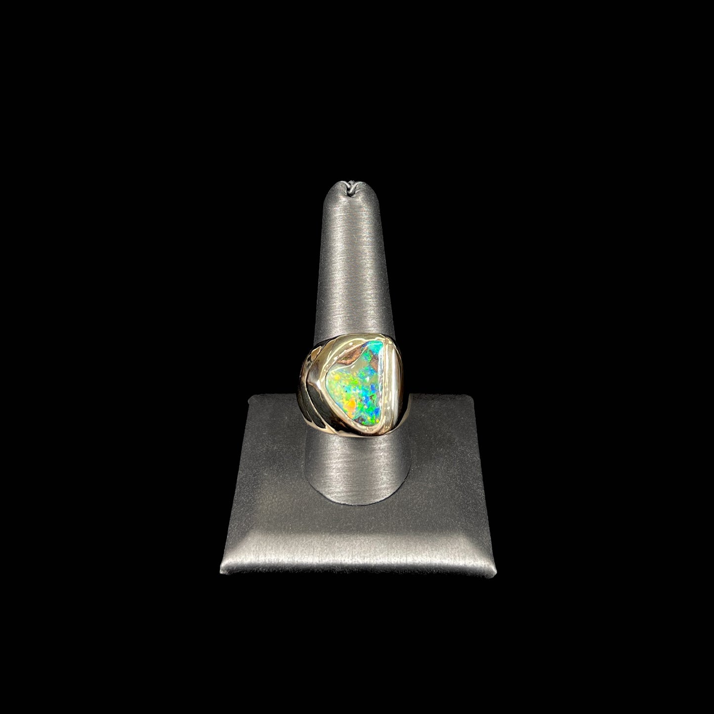 A men's yellow gold solitaire ring set with a triangular shaped natural boulder opal.