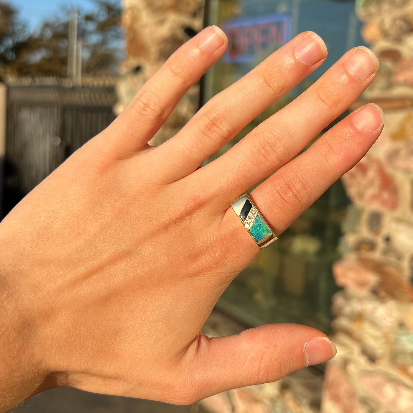 A men's yellow gold ring inlay set with onyx, natural black opal, and four diamonds.