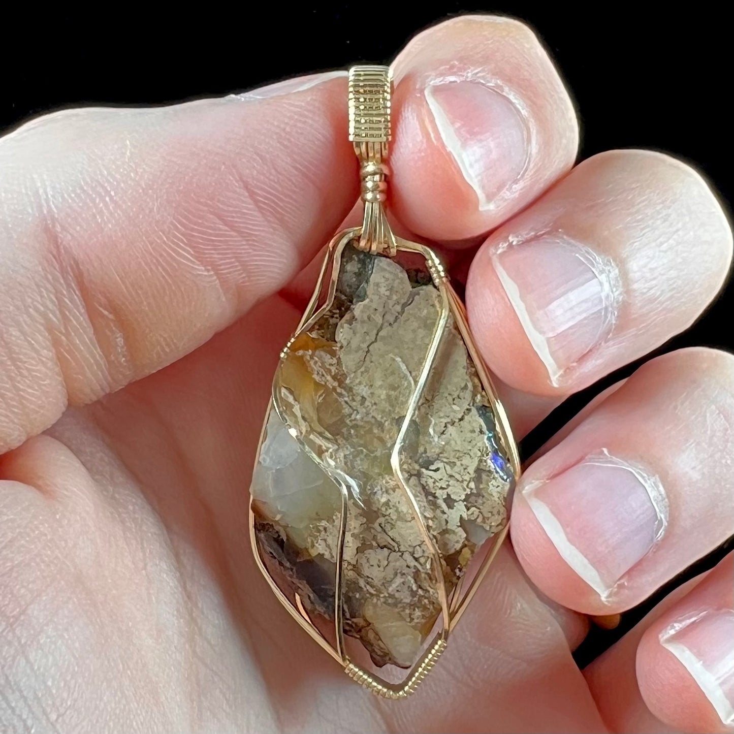 A gold filled wire wrapped pendant set with a natural Virgin Valley, Nevada opal crystal.