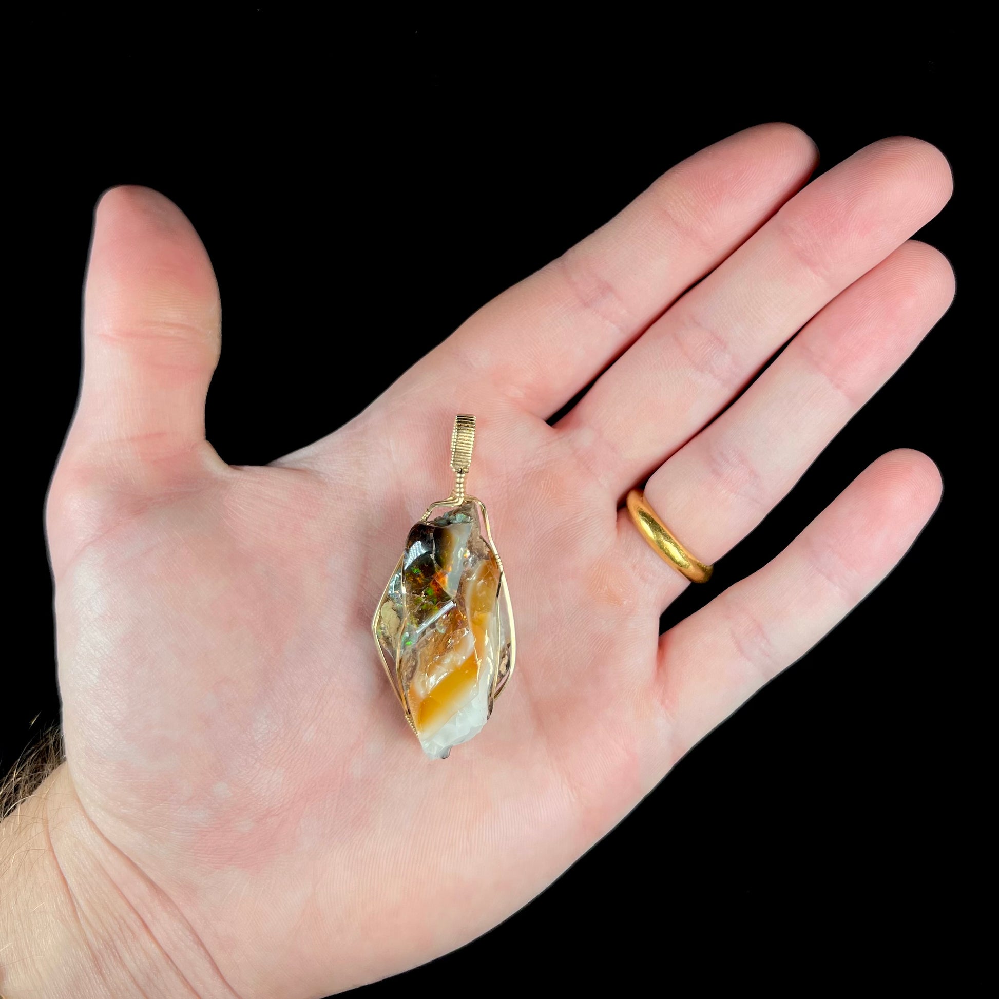 A gold filled wire wrapped pendant set with a natural Virgin Valley, Nevada opal crystal.
