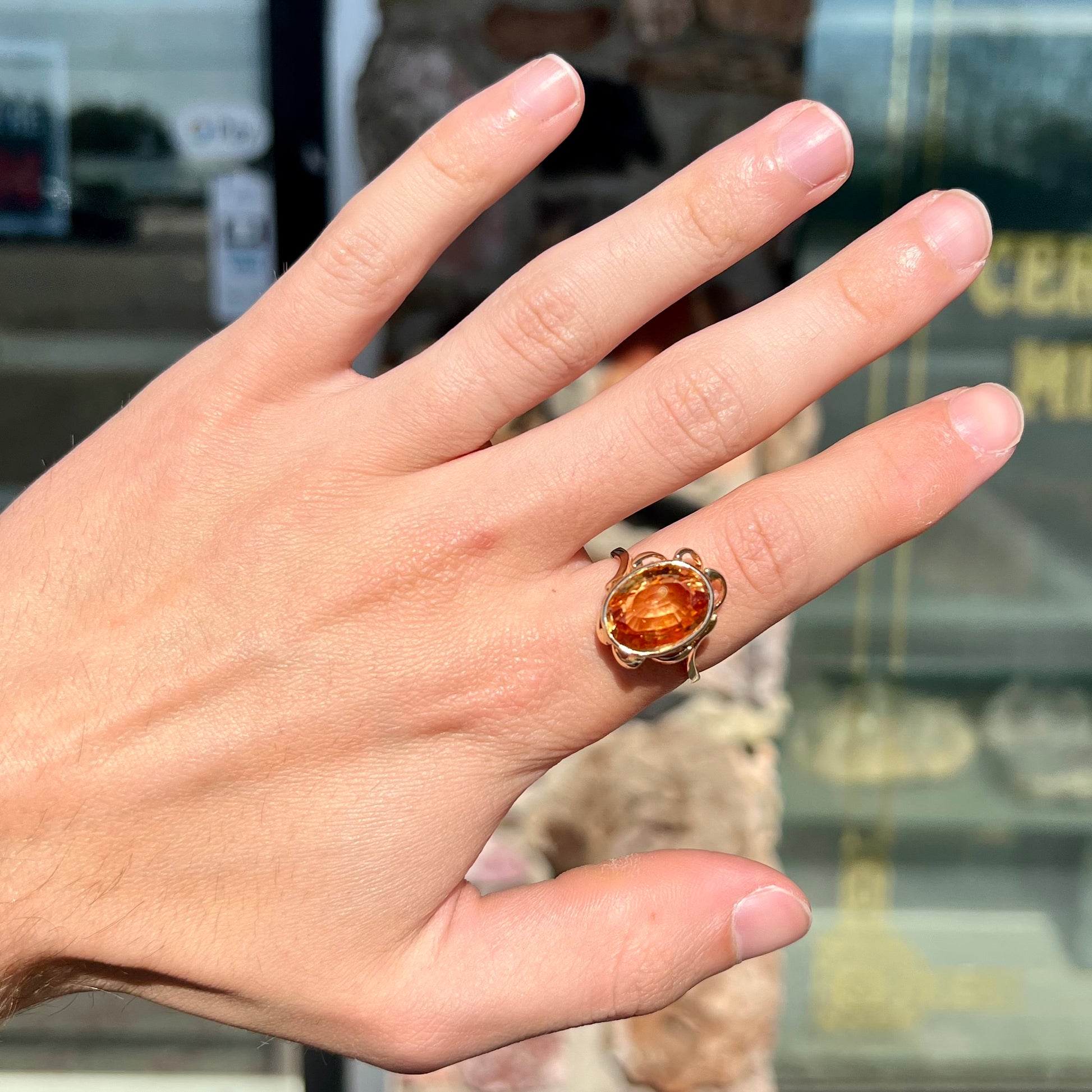 A ladies' yellow gold solitaire ring set with an 8.00 carat oval cut orange hessonite garnet.
