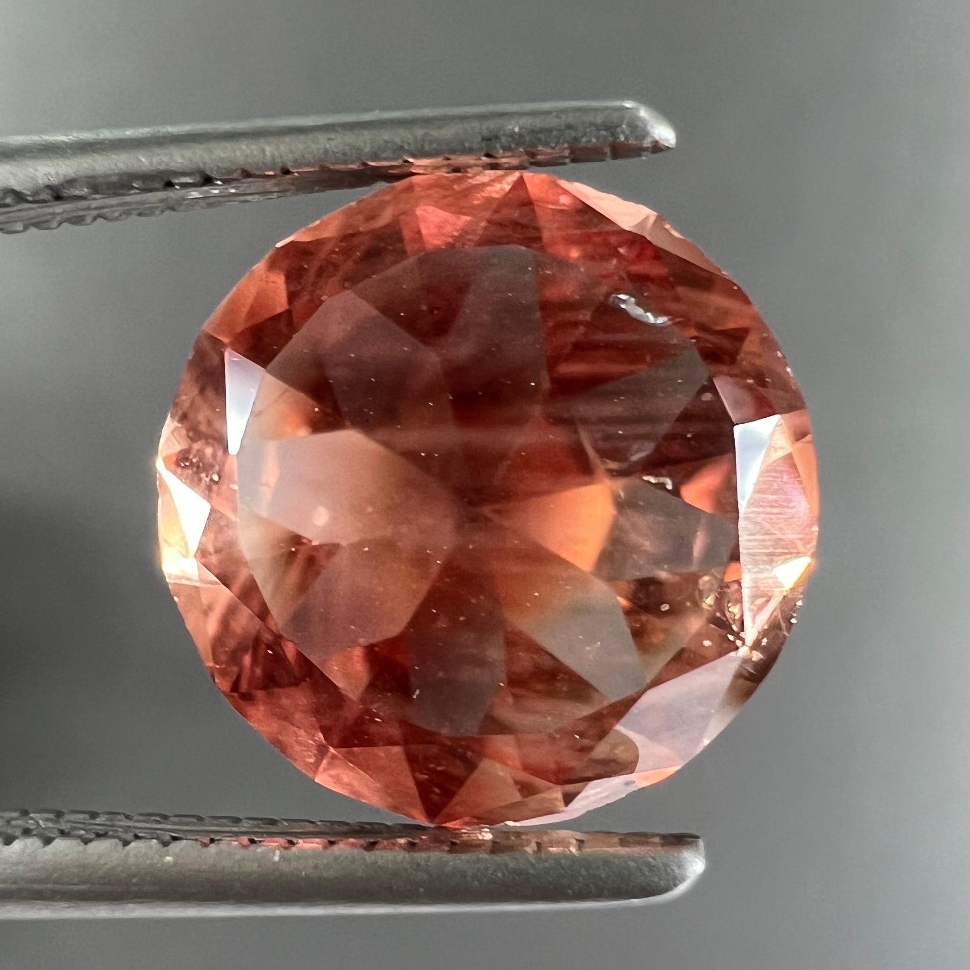 A loose, round brilliant cut Oregon sunstone gem.