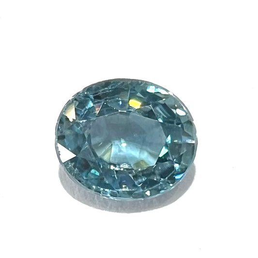 A loose, faceted oval cut blue zircon gemstone.