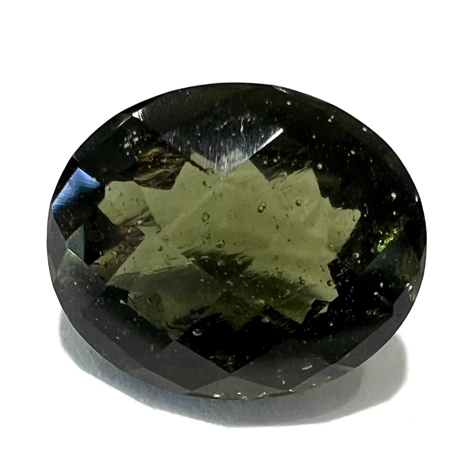 A loose, faceted oval cut natural moldavite gemstone.  The stone weighs 4.16 carats.