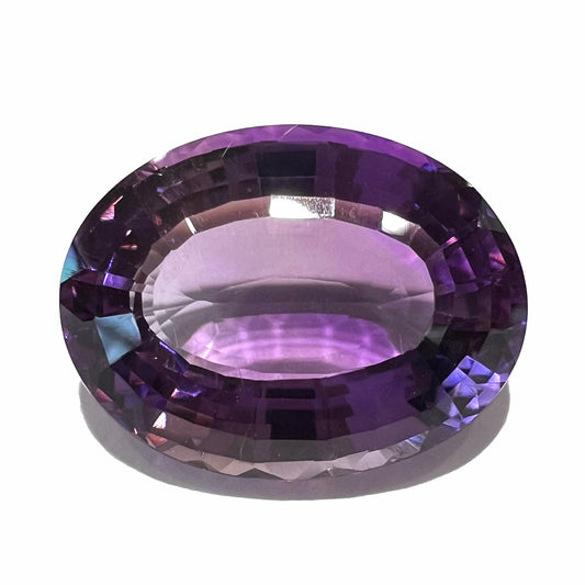 A loose, modified oval step cut amethyst gemstone.  There are light scratches to the table.