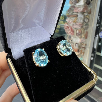 A pair of yellow gold push-back blue topaz stud earrings.