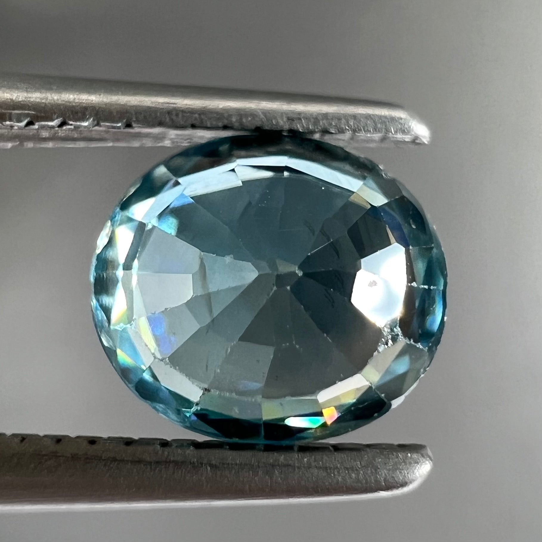 A loose, faceted oval cut blue zircon gemstone.