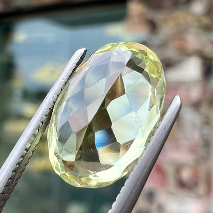 A loose, faceted oval cut chrysoberyl gemstone.  The stone is a greenish yellow color.