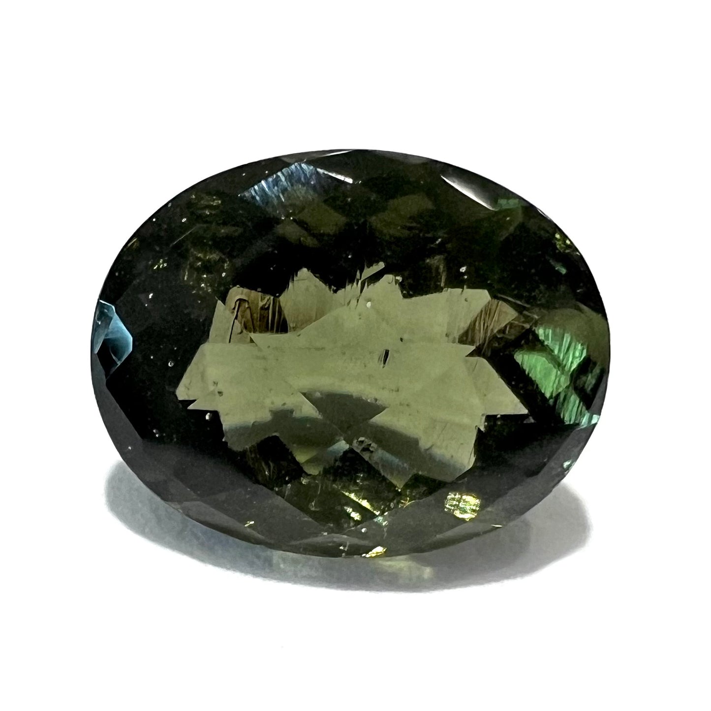 A natural, oval checkerboard cut moldavite gemstone that weighs 2.39 carats.