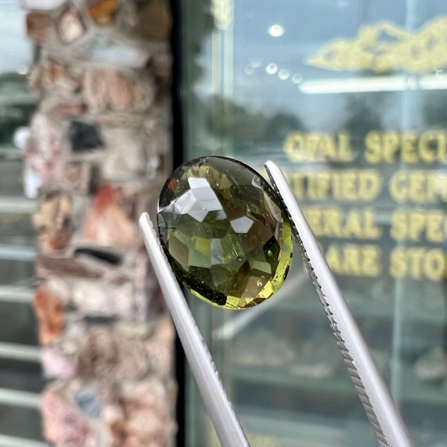 A loose, faceted oval checkerboard moldavite gemstone from the Czech Republic.