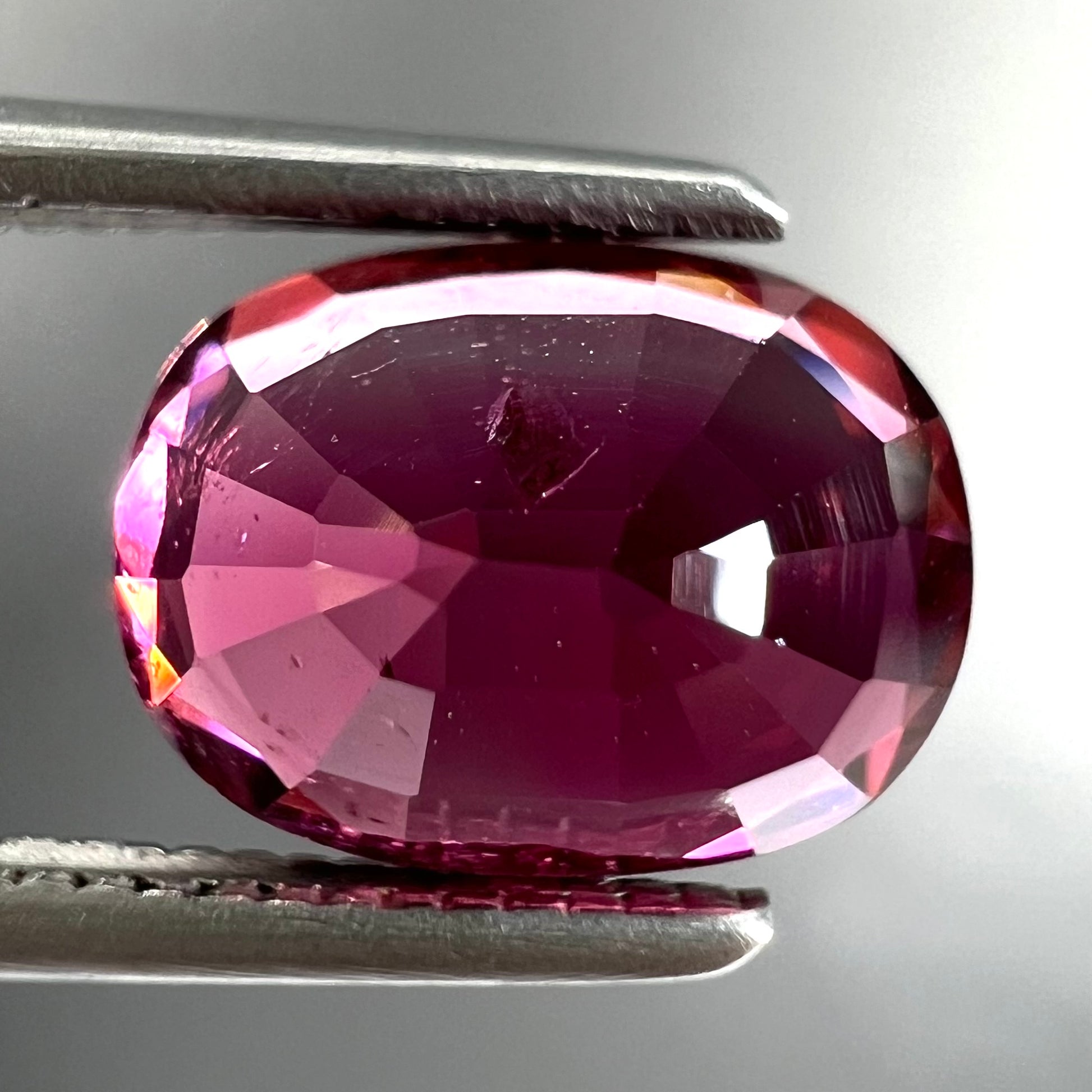 A loose, faceted oval cut purple tourmaline gemstone.  The stone weighs 2.08 carats.