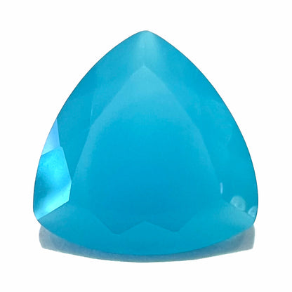 A loose, blue, trillion cut Paraiba chalcedony gemstone.  The color is an electric blue, and the gem weighs 2.76 carats.