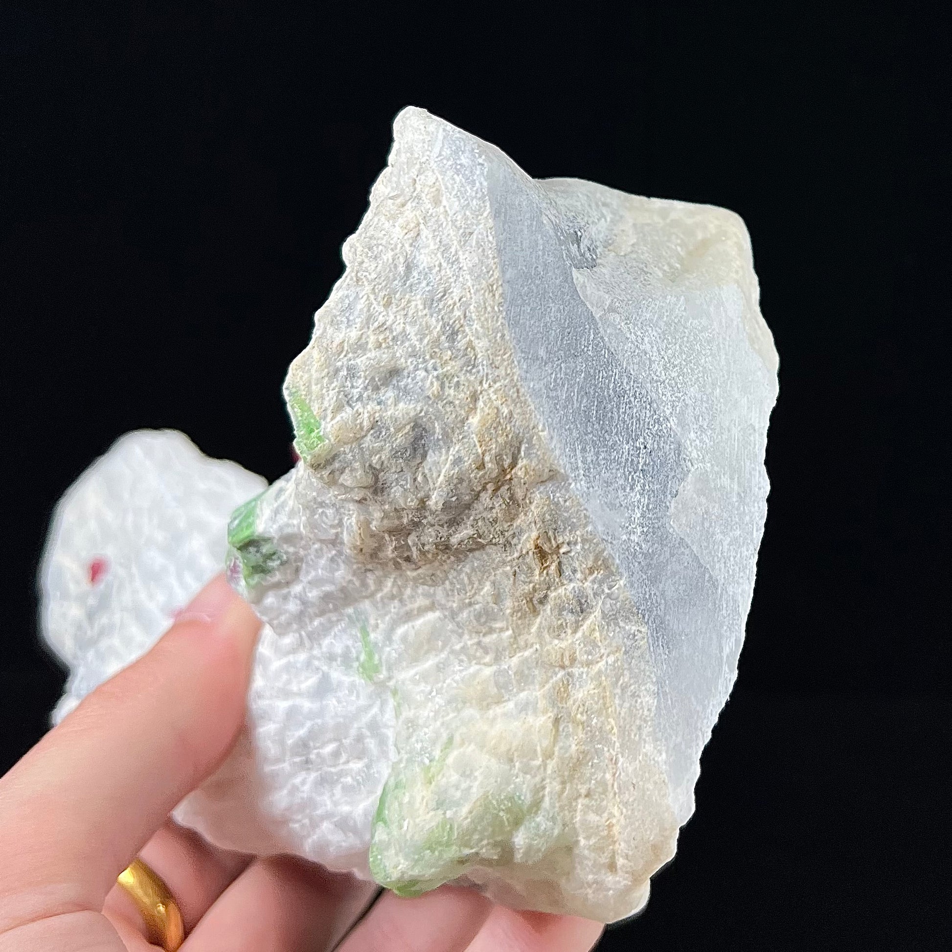 A white calcite specimen embedded with red spinel and green pargasite crystals from Luc Yen District, Vietnam.