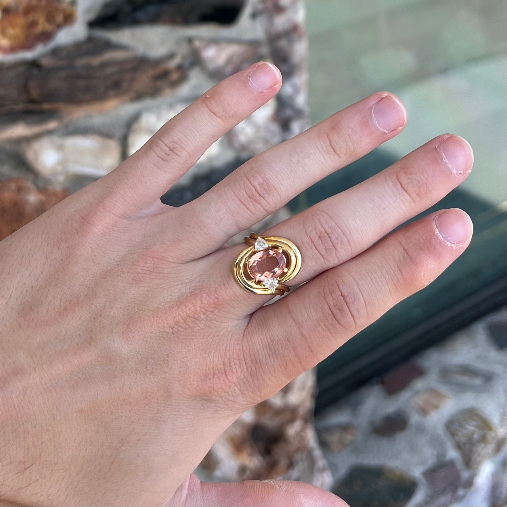 An 18 karat yellow gold ring set with two triangle cut diamonds and a cushion cut imperial topaz.