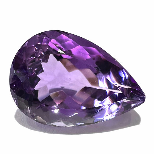 A loose, pear shaped amethyst gemstone.  The stone is a medium purple color.