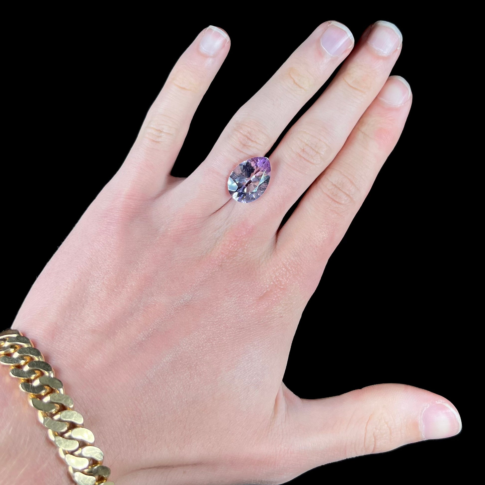 A faceted pear shaped rose de France colored amethyst gemstone.