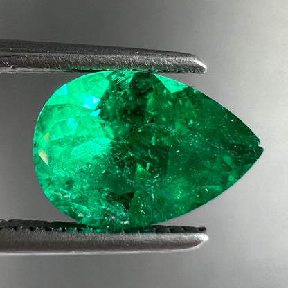 A loose, pear shaped natural emerald gemstone.