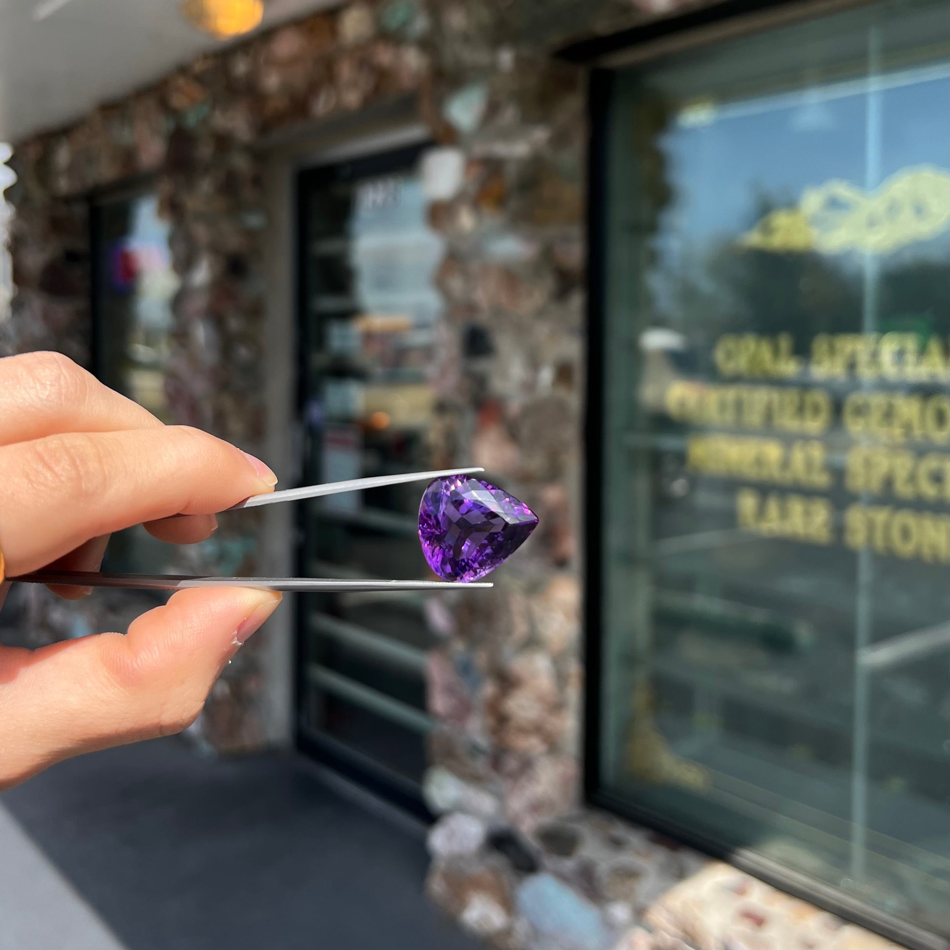 A large, pear shaped amethyst gemstone.  The stone is a dark purple color.