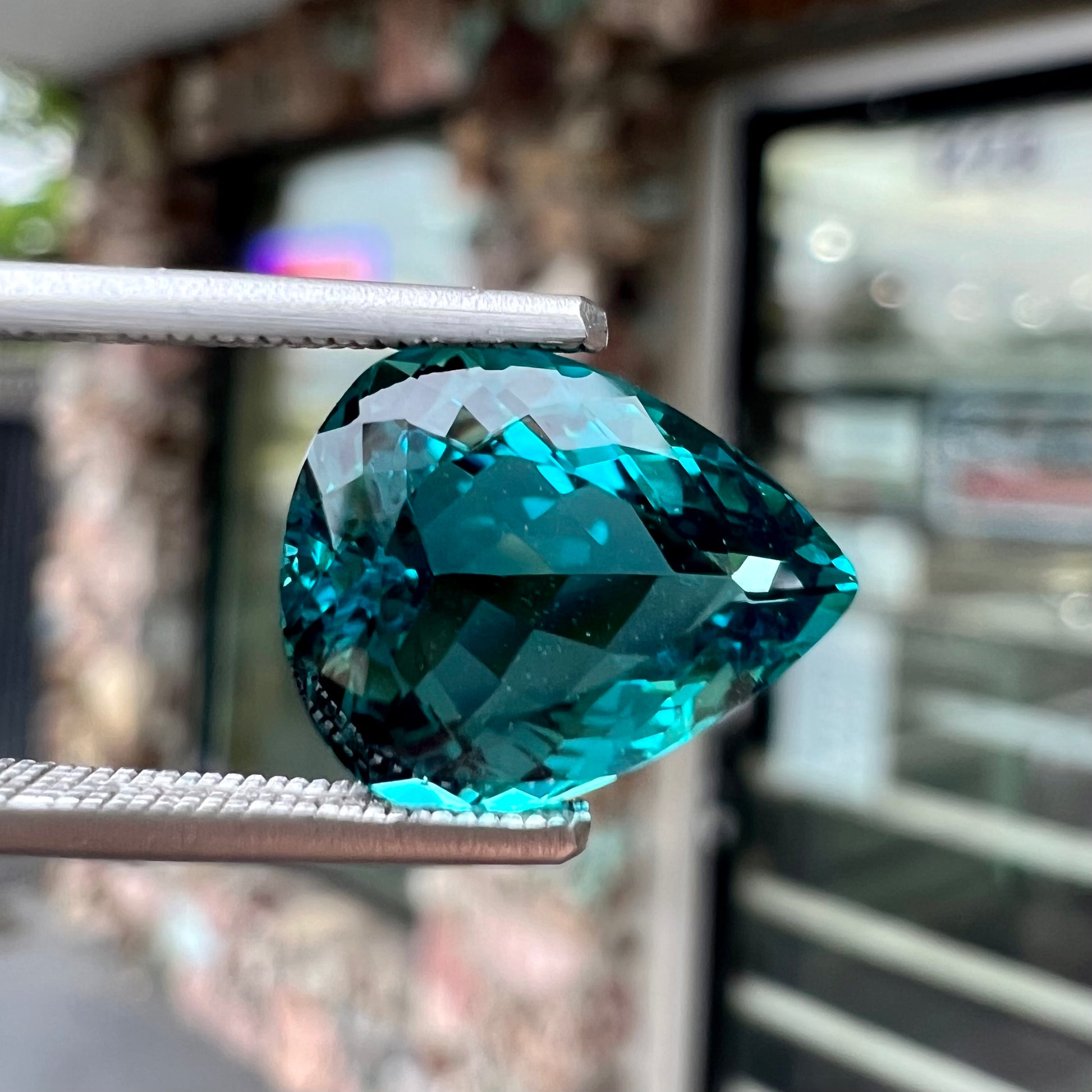 A loose, pear shaped green-blue indicolite tourmaline stone.
