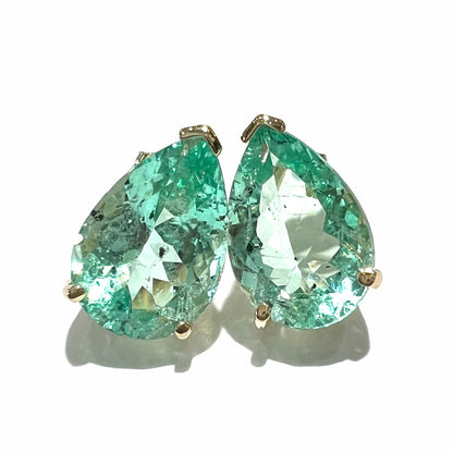 A pair of yellow gold stud earrings set with natural, pear shaped emeralds.