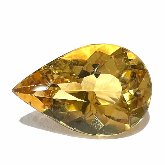 A loose, pear shaped golden beryl gemstone.