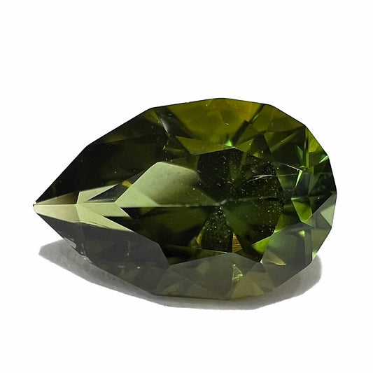 A loose, pear shaped green tourmaline gemstone.  The color is dark green with a yellow secondary hue.
