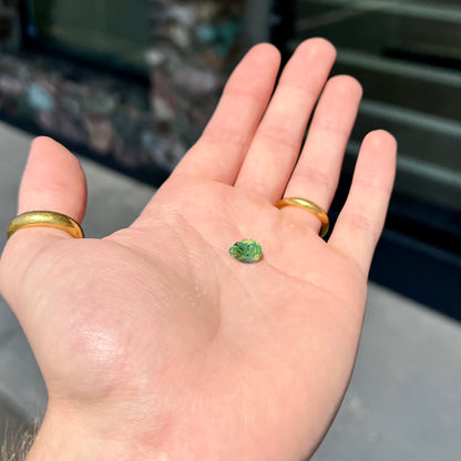 A loose, pear shaped tsavorite garnet gemstone.  The stone is yellowish green.