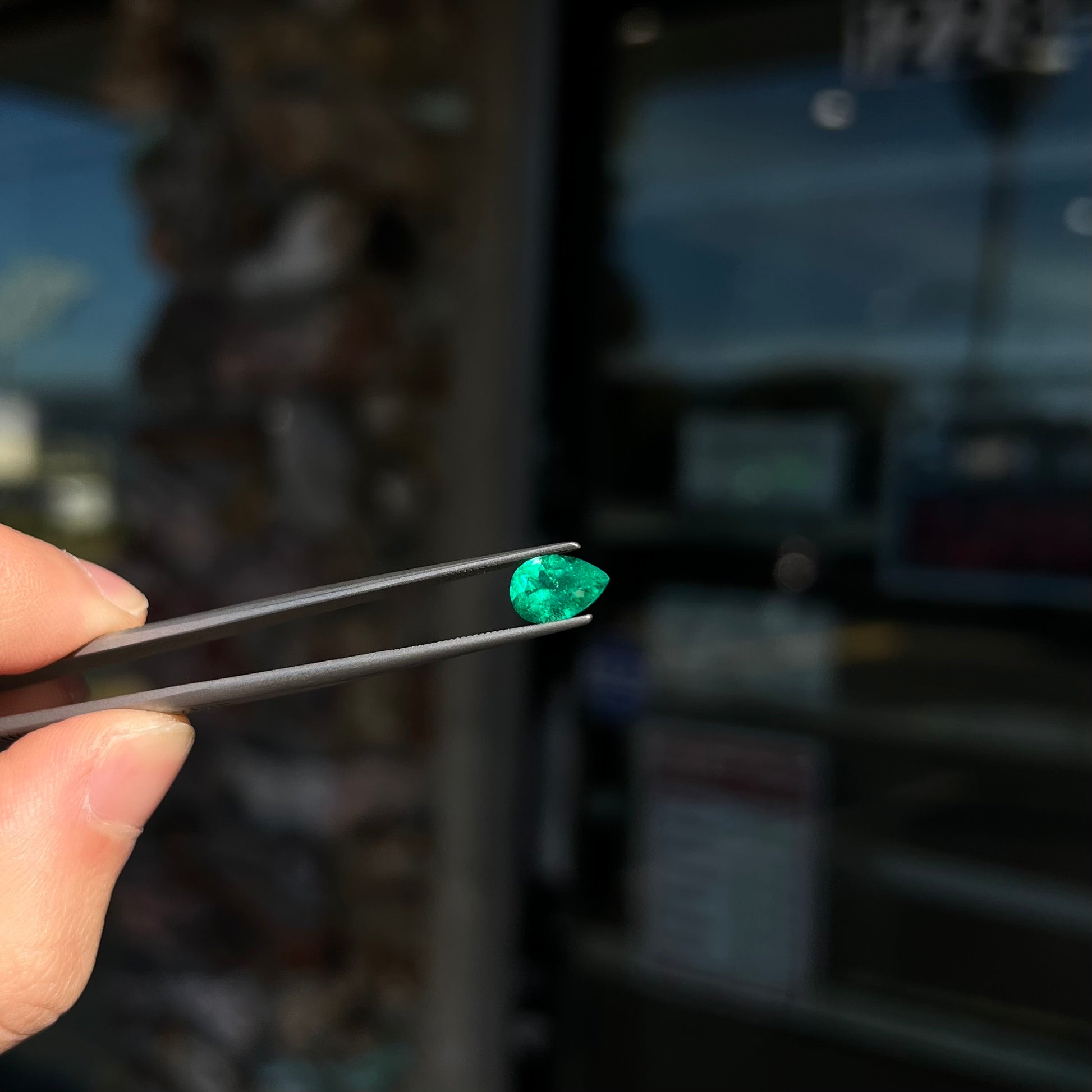 A loose, pear shaped natural emerald gemstone.