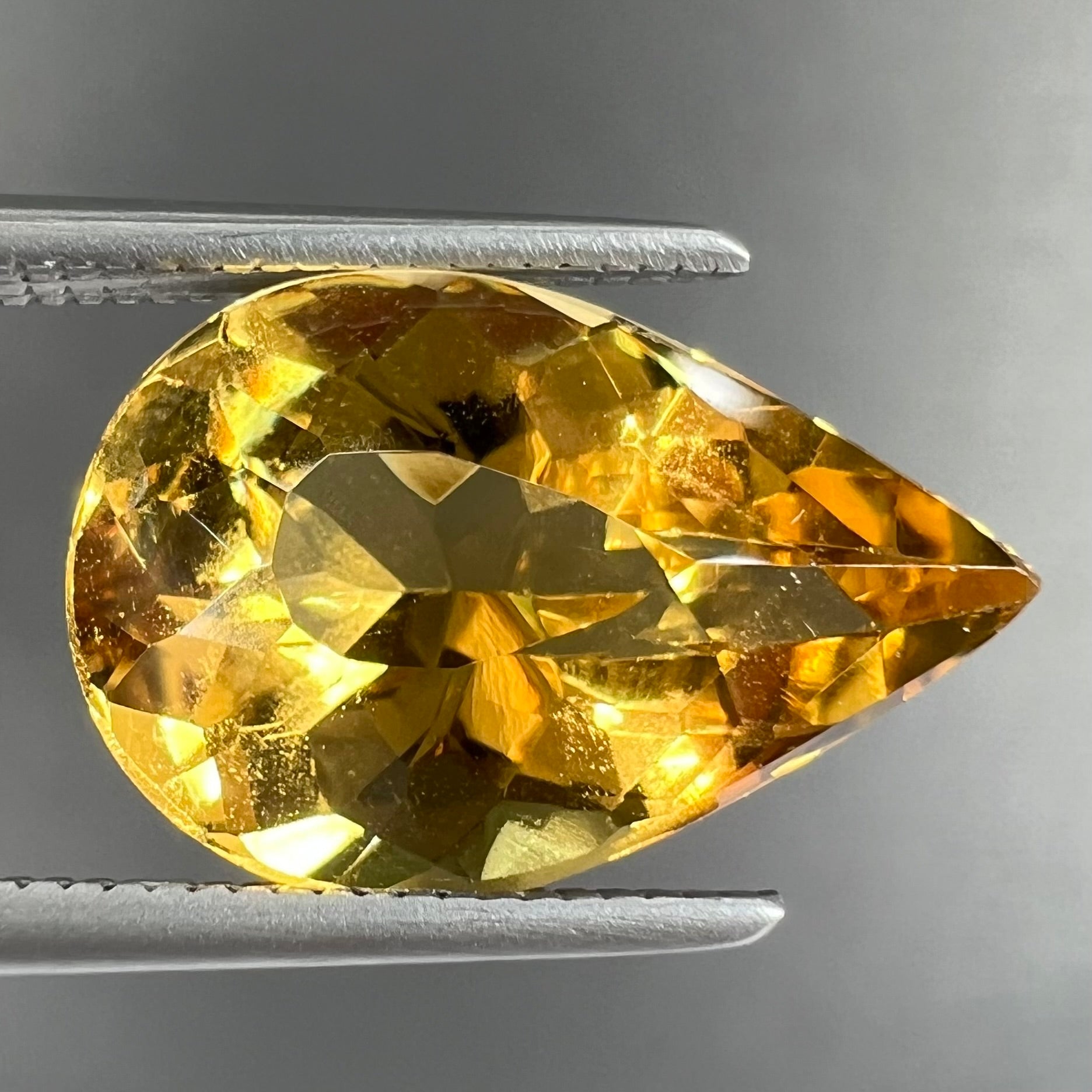 A loose, pear shaped golden beryl gemstone.