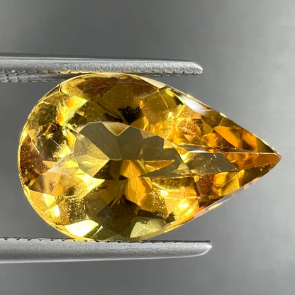 A loose, pear shaped golden beryl gemstone.