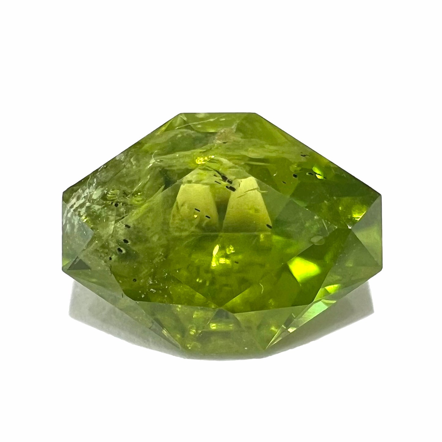 A loose, modified octagon peridot stone.  The stone is a yellow green color.