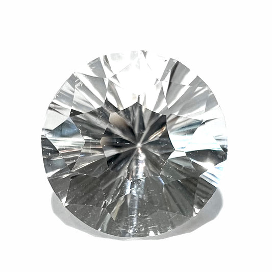 A round brilliant cut petalite gemstone.  The stone is colorless.