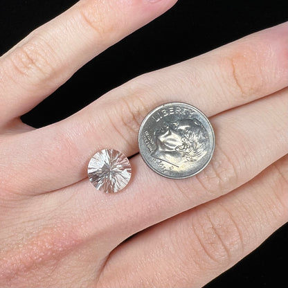 A round brilliant cut petalite gemstone.  The stone is colorless.