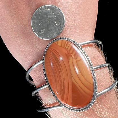 A sterling silver cuff bracelet set with a oval cabochon cut brown Biggs picture jasper stone.