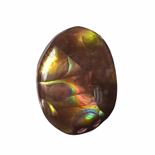 A loose, oval cabochon cut Mexican fire agate stone with pink, orange, and purple banding.