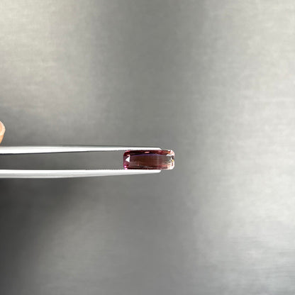 A loose, modified emerald cut tricolor tourmaline.  The stone transitions from pink to light pink to white colors.
